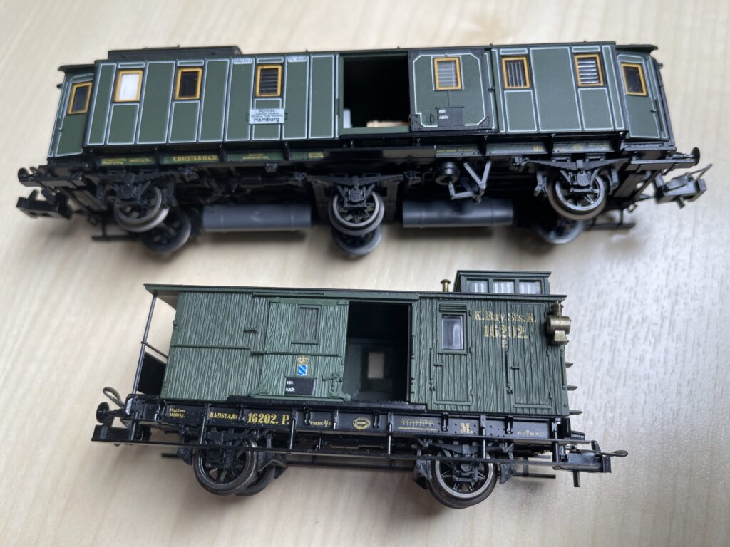 Beide grünen Wagen liegen auf der Seite. Die Schiebetüren sind offen. Aufschrift K. Bay. Sts. B.