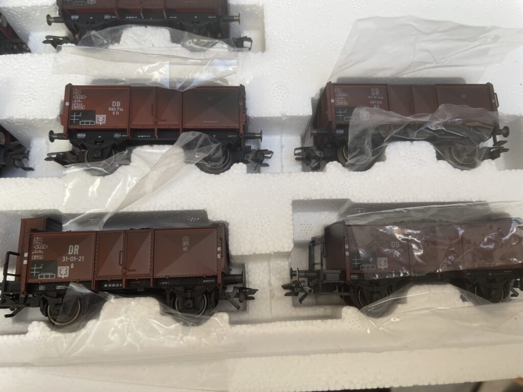 Nachaufnahme von vier Wagen. Gut ist die schwarze Färbung zu erkennen. Sonst sind die Wagen braun mit schwarzem Fahrgestell.